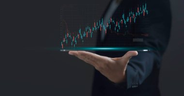 Bir adam üzerinde grafik olan bir tablet tutuyor. Grafik bir düşüş eğilimi gösteriyor, bu da değer kaybı ya da performans düşüşüne işaret edebilir.