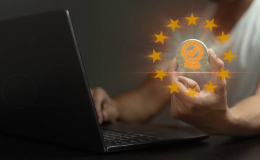 Bir kişi üzerinde altın yıldız olan bir dizüstü bilgisayar tutuyor. Başarı ve başarı kavramı, altın yıldız yüksek bir başarı ya da tanınma düzeyini temsil eder.