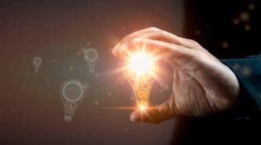 Yaratıcılık ve yeni fikirler kavramı. Elinde ampulü tutan adam.