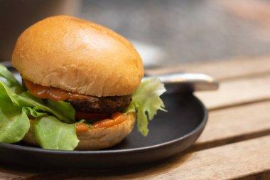 Et, turşu ve ketçaplı hamburgerler ahşap masada..