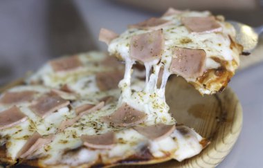 Bir dilim pizzayı yakın plan çek. Belirli bir alana seçici odaklanma.