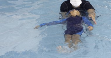 Küçük kız birlikte yüzmeyi öğreniyor.