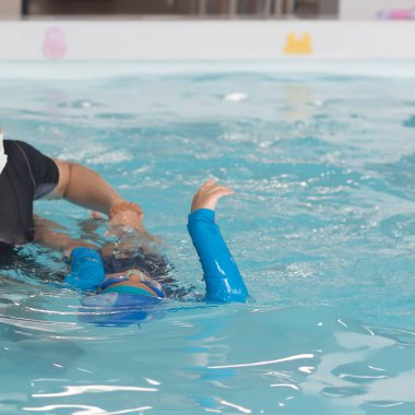 Küçük kız birlikte yüzmeyi öğreniyor.