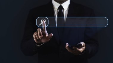 İşadamı akıllı telefon kullanıyor ve koyu mavi arka planda arama çubuğuna dokunuyor.