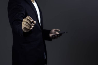 İş adamı karanlık arka plana karşı stil kalem ve akıllı telefon kullanıyor.