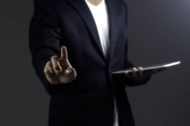 İşadamı dijital tablet tutuyor ve arka plana işaret ediyor. 