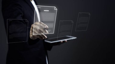 İşadamı dijital tablet tutuyor ve e belgesinde karanlık arkaplana karşı sanal ekranda stil kalem imzası kullanıyor.