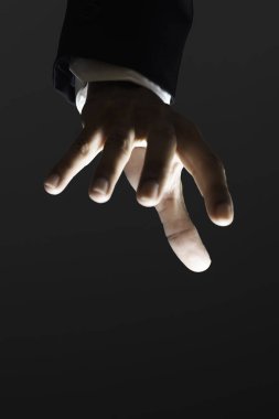 İş adamının elinin yakın plan çekimleri karanlık arka plana karşı kuklayı kontrol ediyor.