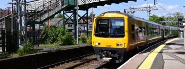 Geniş ekran panoramik anamorfik elektrikli tren videosu, banliyö hattındaki İngiliz kırsal istasyonundan geçen tren. Batı Midlands İngiltere - İngiliz demiryolları. 