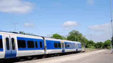 Warwick, Warwickshire, İngiltere yakınlarındaki Hatton istasyonundan geçen bir Ağ Demiryolu yolcu treninin 8K görüntüsü..