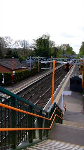 垂直4K视频 绿色电气化火车站 供乘客通勤和货运使用 西米德兰英国 视频剪辑