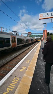 Birmingham 'ın banliyölerinde demiryolu ağı yolcusu banliyö treni. Batı Midlands, İngiltere. Tren geliyor, gidiyor, kırsal tren istasyonundan geçiyor..