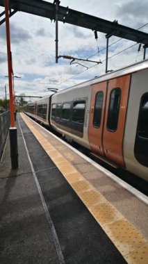 Birmingham 'ın banliyölerinde demiryolu ağı yolcusu banliyö treni. Batı Midlands, İngiltere. Tren geliyor, gidiyor, kırsal tren istasyonundan geçiyor..