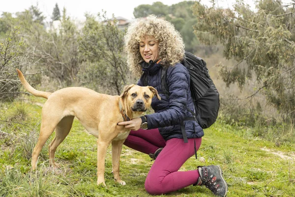 Kręcone Włosy Kobieta Alpinistka Jej Pies Pozowanie Świeżym Powietrzu Podczas — Zdjęcie stockowe