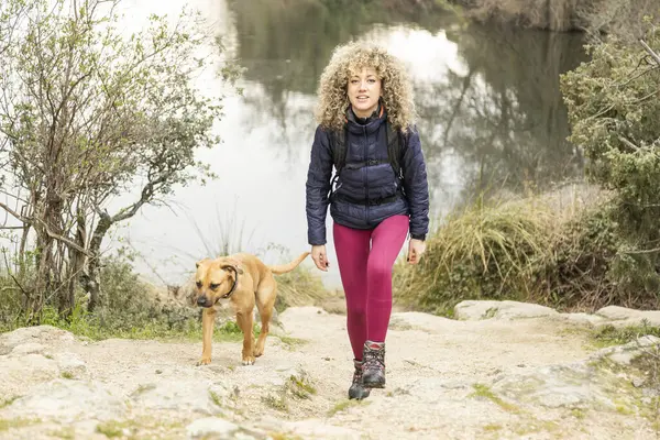 Kręcone Blond Włosy Kobieta Alpinistka Jej Pies Spacerujący Górach — Zdjęcie stockowe