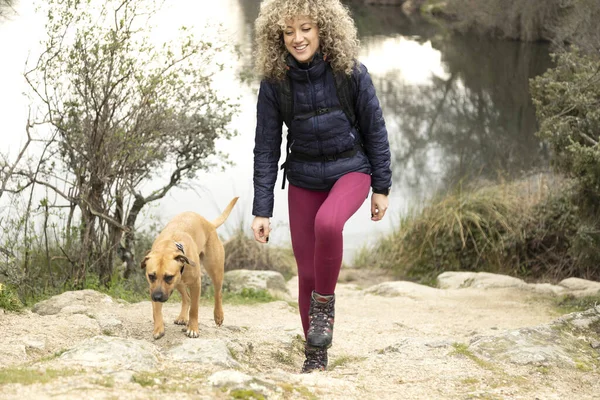 Kręcone Blond Włosy Kobieta Alpinistka Jej Pies Spacerujący Górach — Zdjęcie stockowe