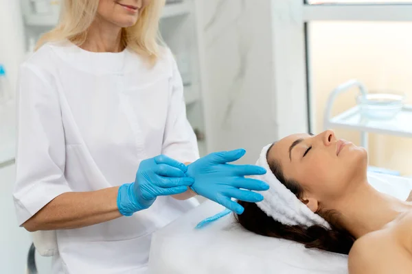 Cosmetologo Indossando Guanti Protettivi Blu Preparare Esaminando Volto Del Cliente — Foto Stock