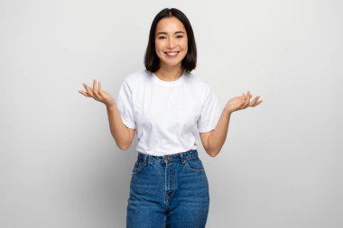 Kollarını kaldırmış belirsiz pozitif kadın, ne yapacağını bilmiyor. Beyaz arka planda izole edilmiş kapalı stüdyo görüntüleri