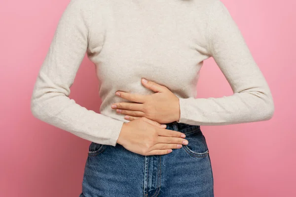 胃の痛み 胃炎や便秘に苦しむ腹をクラッチ女性の作物ビュー 屋内スタジオはピンクの背景に隔離されたショット 期間けいれんの概念 — ストック写真