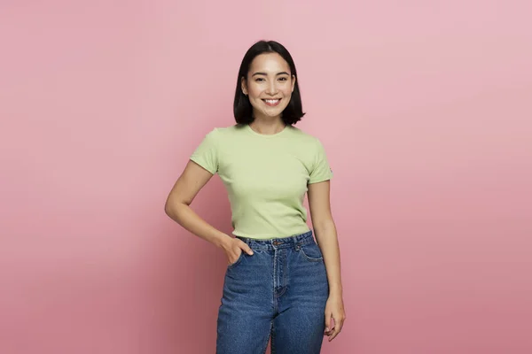 stock image Portrait of happy successful asian woman standing, looking at camera with charming smile. Indoor studio shot isolated on pink background 