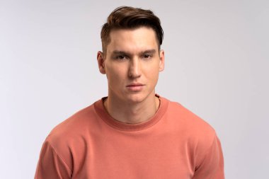 Ciddi bir ifadeyle kameraya bakan özgüvenli bir adamın portresi. Gülümsemeyen kararlı bir iş adamı. Stüdyoda çekim izole edildi 