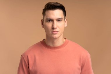 Ciddi bir ifadeyle kameraya bakan özgüvenli bir adamın portresi. Gülümsemeyen kararlı bir iş adamı. Stüdyoda çekim izole edildi 