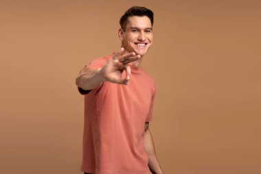 Her şey yolunda. Tatmin olmuş bir adam parmaklarıyla iyi niyet gösteriyor, işi onaylıyor, kaliteyle tatmin oluyor. Bej arka planda izole edilmiş kapalı stüdyo çekimleri 