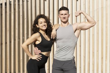 Sportive people showing fit bodies and posing on city street. Sport and recreation concept. Stock photo 