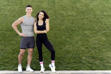 Positive sportive people standing over grass background. Sport and recreation concept. Stock photo 