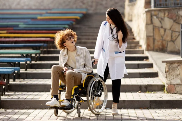 Молодий Пацієнт Візку Посміхається Лікарю Приваблива Медсестра Розмовляє Пацієнтом Відкритому — стокове фото