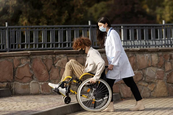 Приваблива Жінка Лікар Захисній Масці Допомагає Пацієнту Інвалідному Візку Вгору — стокове фото