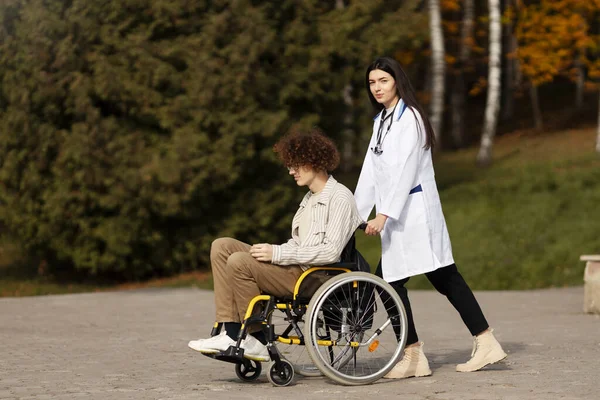 Піклуючись Молода Медсестра Носить Свого Пацієнта Інвалідному Кріслі Щасливий Пацієнт — стокове фото