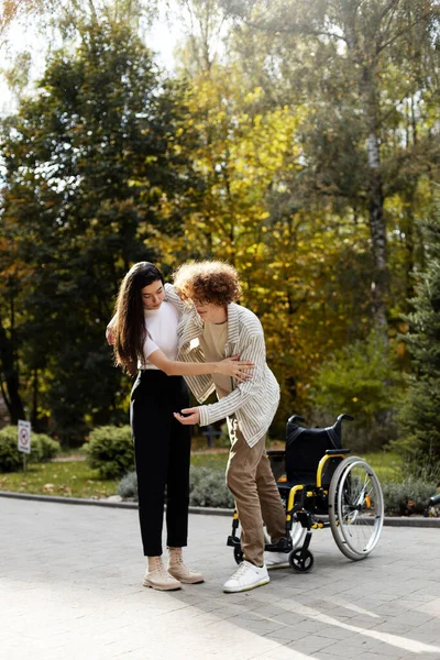 Приваблива Молода Дівчина Допомагає Молодому Чоловікові Встати Інвалідного Візка Молода — стокове фото