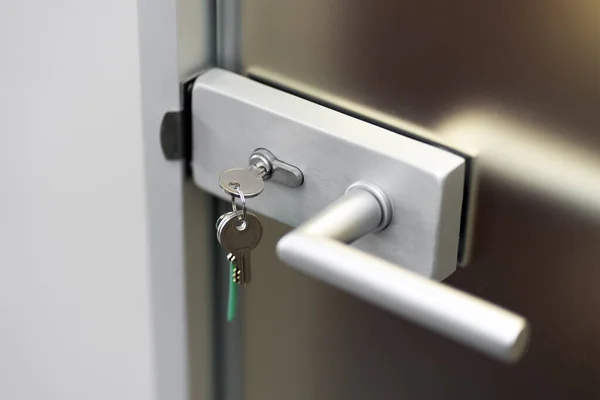Modern door, key in the core of the lock, secure lock, security concept, closed door, closeup.