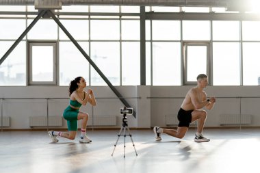 Sportif Latin erkek ve kadın spor salonunda online antrenman yapıyor, egzersiz yapıyor. Çift eğitim kavramı