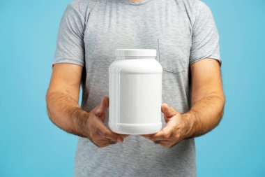 Beyaz plastik kavanoz takviyesi sunan bir adama yaklaş. Ürün tasarımını sergilemek için mükemmel.