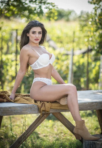 Sinnliche Brünette Frau Mit Sexy Weißen Dessous Posiert Auf Holztisch — Stockfoto