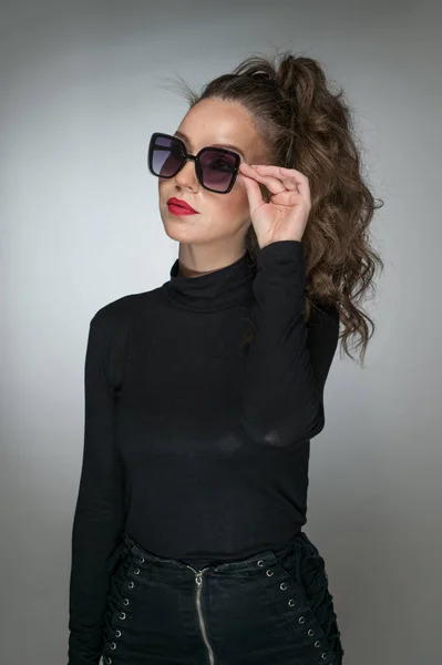 Kobieta Okularach Przeciwsłonecznych Czarnej Bluzce Szarym Tle Styl Piękna Dziewczyna — Zdjęcie stockowe