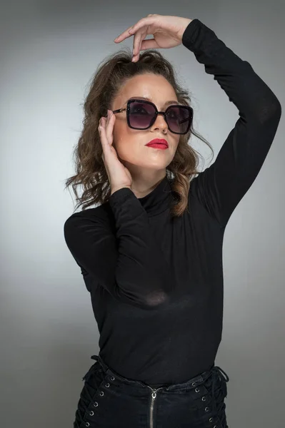 Frau Mit Sonnenbrille Und Schwarzer Bluse Vor Grauem Hintergrund Stil — Stockfoto