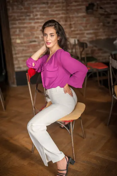 Frumoasă Tânără Brunetă Într Bluză Violet Pantaloni Albi Care Prezintă Fotografie de stoc