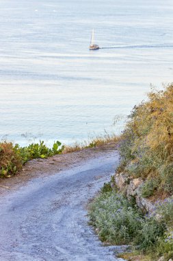 Yunanistan sularında günbatımında manzaralı yüksek yol ve yelkenli bir yat