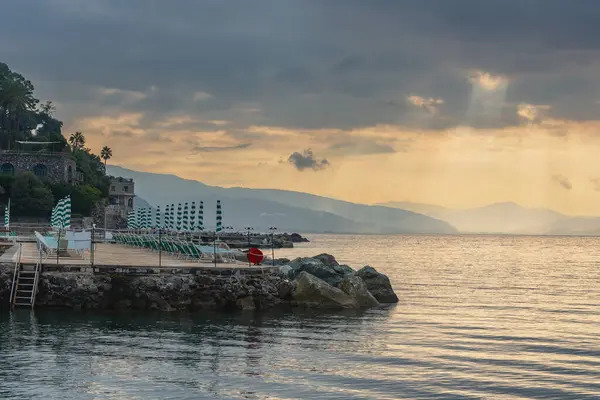 Stock image Beach of the Liguria coastline, Italian Riviera. Coastal village Santa Margherita Ligure. Seascape. Stone beach with ambrellas and sunbeds.