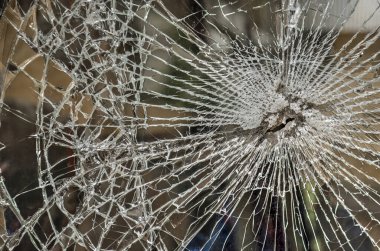 Çekiçle, kurşunla ya da nispeten küçük bir objeyle vurulmuş bir pencerenin camında çatlaklar var.