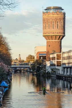 Utrecht, Hollanda, 14 Kasım 2022: Vaartsche Rijn boyunca tek kürek çeken ve tarihi bir su kulesi olan