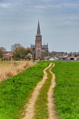 Schalkwijk, Hollanda, 8 Nisan 2023: çayırların arasından köy kilisesine giden patika.