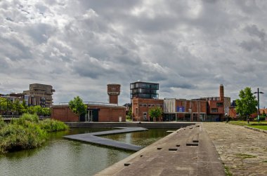 Enschede, Hollanda, 9 Ağustos 2023: Roombeek Mahallesi 'nin üzerinde yangın söndürme felaketinden sonra inşa edilen tekstil fabrikaları ve yeni binalarla dramatik bir gökyüzü.