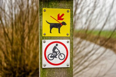 Montfoort, Hollanda, 13 Ocak 2024: Yürüyüş yolunda bisiklet ve köpeklere tasma takılmayacağına dair işaretler var.