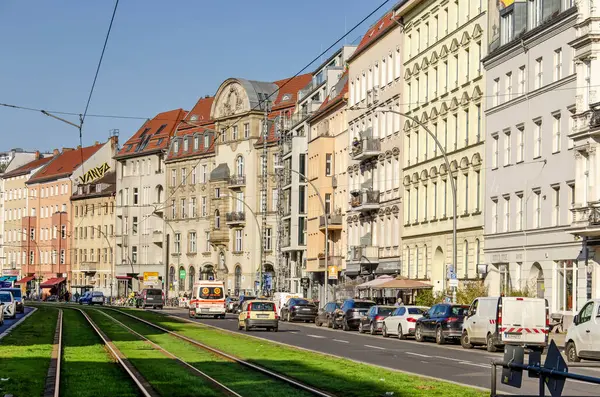 Berlin, Almanya, 6 Mart 2024: Mitte bölgesindeki Torstrasse boyunca otla kaplı bir tramvayın her iki tarafında da araba şeritleri var.