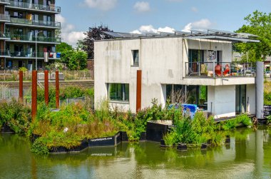 Rotterdam, Hollanda, 17 Temmuz 2024: Persoonshaven limanında güneşli bir yaz gününde yüzen villa ve yüzen park