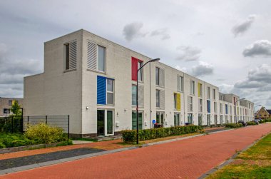 Lelystad, Hollanda, 4 Ağustos 2024: Birincil renklerle süslenmiş beyaz tuğlalı yeni yapılmış evler